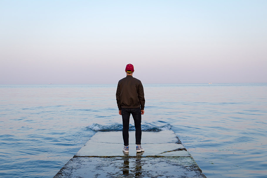 man alone facing sea