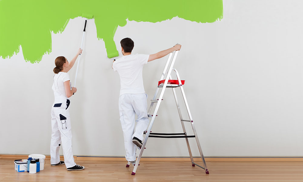 Young Couple Painting Wall Together